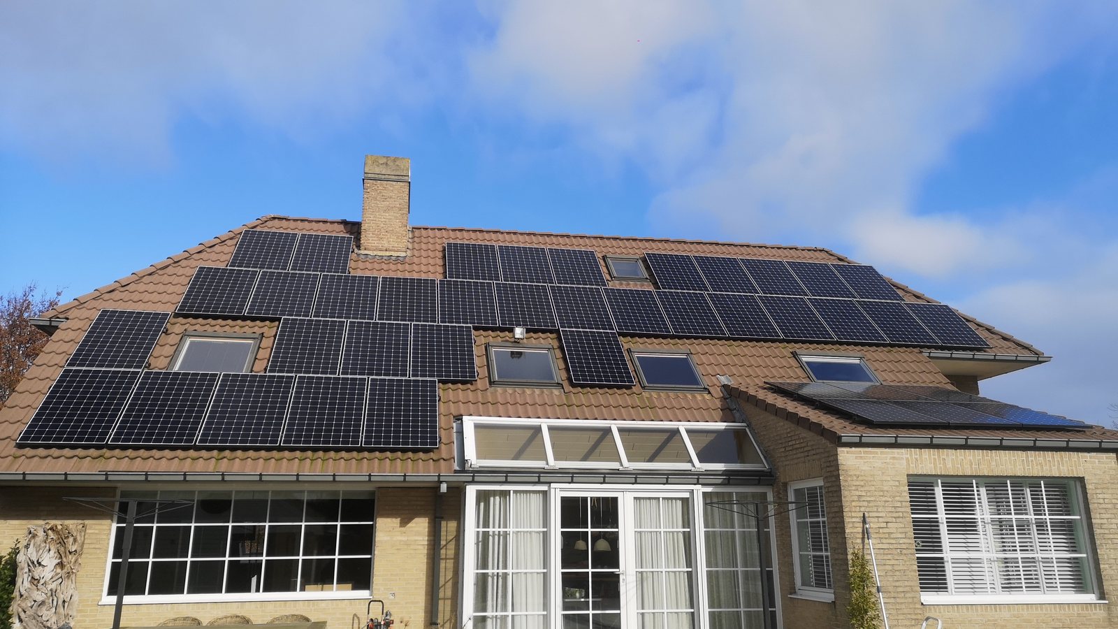Woning met zonnepanelen op het dak en witte ramen