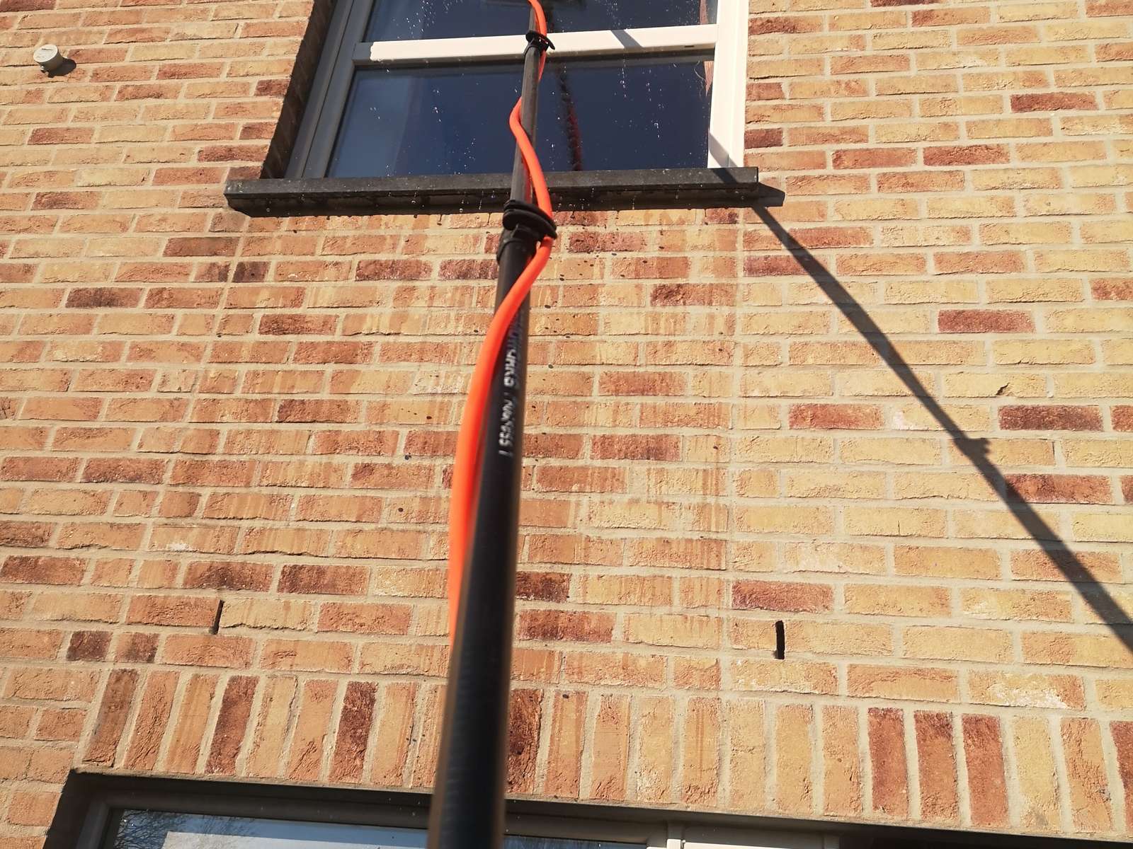 Telescoopsteel tegen een raam in een bakstenen gevel